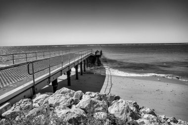 Bundegi Sahili 'nde rahatlatıcı kıyı manzarası Batı Avustralya Sahili, dalgalar ve güneş ışığı vurguluyor.