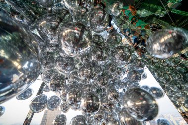 Modern iç uzayda yansıtıcı balonlar insanların ve nesnelerin yansımalarını yakalıyor..