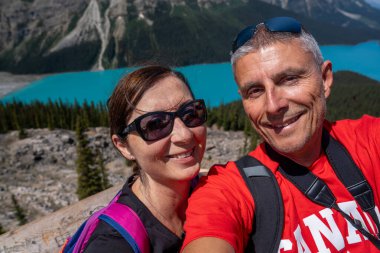 Mutlu aile, güneşli yaz gününde Banff Ulusal Parkı 'nda Peyto Gölü manzarasıyla eğleniyor..