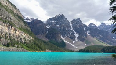 Banff Ulusal Parkı 'ndaki Moraine Gölü Alberta' da berrak su ve alp yaz manzarası sergileniyor.