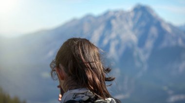 Genç kız güneşli bir yaz günü Banff dağlarının akıllı telefonuyla fotoğraflarını çekiyor..