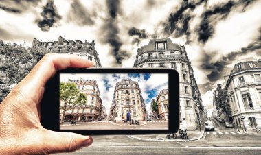 Siyah ve beyazdan renkleri alıyor. Akıllı telefonlu bir kadın Paris 'in fotoğrafını çekiyor. Turizm konsepti.