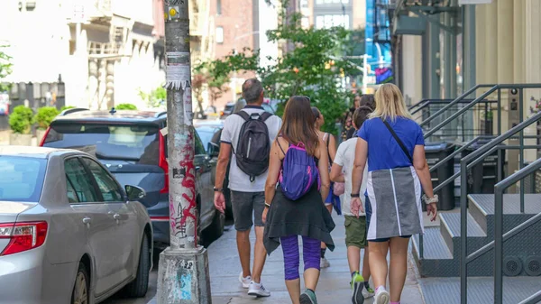 Kafkasyalı ebeveynler ve çocuklar New York sokaklarında gün ışığında geziyorlar..