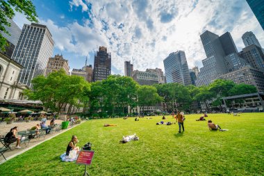 New York City, New York - 12 Haziran 2025: Güneşli yaz günü Bryant Park 'ın çimlerinde dinlenen turistler ve yerel halk.