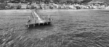 Spiaggia di Alassio 'nun turkuaz deniz ve kasaba manzaralı perspektifi.