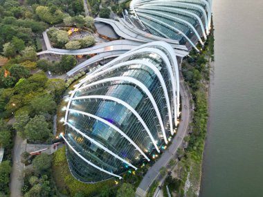 Güneşin battığı gün batımında Singapur, Körfez yakınlarındaki Bahçeler 'deki Çiçek Kubbesi ve Bulut Ormanı' nın gökyüzü manzarası aydınlık cam kubbeler ve yemyeşil yeşil.