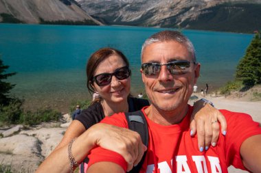 Banff Ulusal Parkı 'nda güneşli yaz gününde Peyto Gölü' nün tadını çıkaran mutlu beyaz çift..