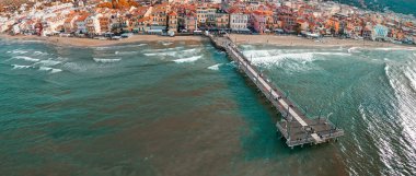 Spiaggia di Alassio 'nun turkuaz deniz ve kasaba manzaralı perspektifi.
