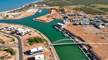 İskeleleri, gemileri ve parlak güneş ışığıyla Batı Avustralya İhracat Limanı manzaralı hava perspektifi.