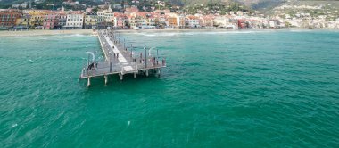 Spiaggia di Alassio 'nun turkuaz deniz ve kasaba manzaralı perspektifi.