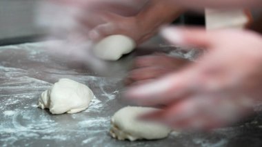 Pizza hamuru toplarını elle şekillendiriyorum. Taze İtalyan pizzası pişirmeye hazırım..