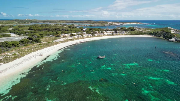 Rottnest Adası sahil şeridinin panoramik manzarası berrak suları ve güneş ışığında el değmemiş plajı gösteriyor..