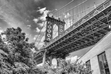 Manhattan ve Brooklyn arasında East River üzerinde Manhattan Köprüsü güneşli bir günde iki tuğla bina tarafından çevrelenmiş dar bir ara sokaktan ve DUMBO, Brooklyn, New York 'taki Plymouth Caddesi' nden görüldü..
