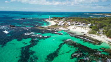 Rottnest Adası kıyı şeridinin noramik hava manzarası berrak suları ve güneş ışığında el değmemiş plajı gösteriyor..