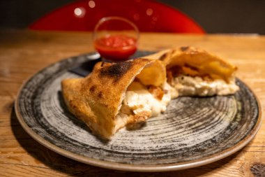 Profesyonel mutfakta geleneksel calzone hazırlanıyor. Taze malzemelerle pişirmeye hazır..