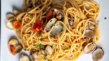 Siyah tabakta taze pişmiş makarna. Zarif yemek fotoğraflarında otlar ve malzemeler var..