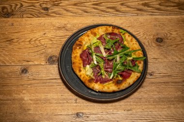 Lezzetli taze pişmiş pizza. Masada servis ediliyor. Soslar ve peynirle birlikte yemeye hazır..