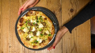 Lezzetli taze pişmiş pizza. Masada servis ediliyor. Soslar ve peynirle birlikte yemeye hazır..