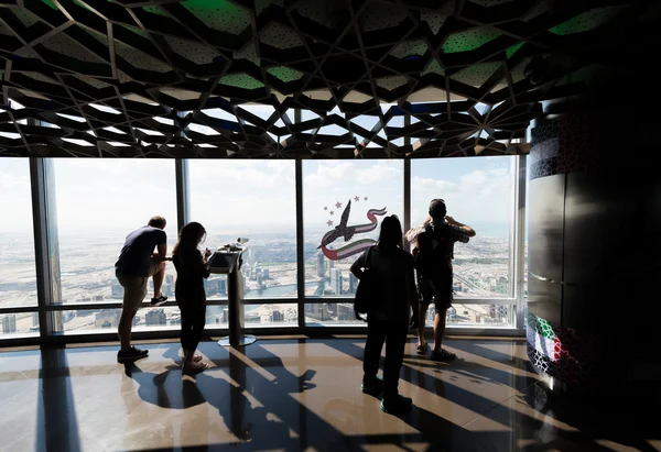 Toeristen met uitzicht op de moderne stad van een hoog uitkijkpunt — Stockfoto