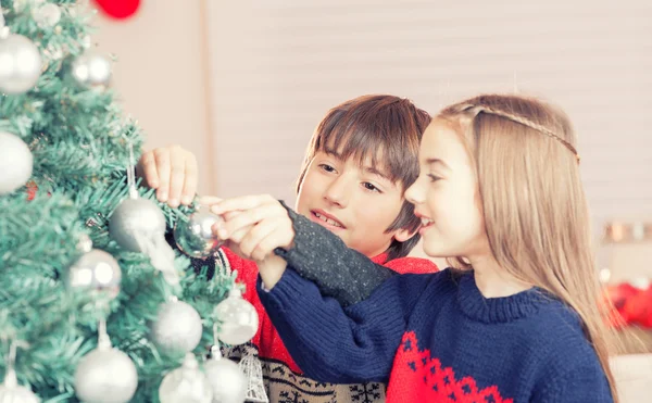 Boy and girl decorating Christmas tree — Stock Photo, Image