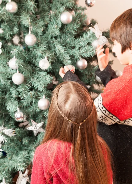 Jongen en meisje op kerstboom — Stockfoto