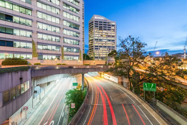 Senderos ligeros de coches que se aceleran a lo largo de la ciudad moderna — Foto de Stock
