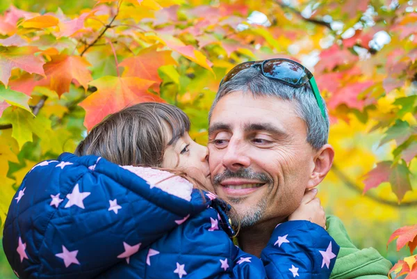 Daughter kissing father in park — Stock Photo, Image
