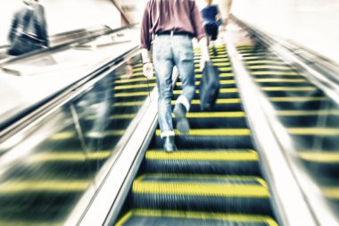 İnsanlar hızlı hareketli yürüyen merdiven üzerinde