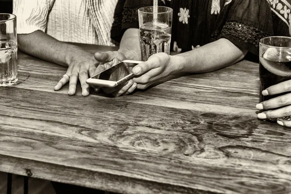 Assis sur la table et relaxant avec smartphone — Photo