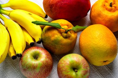 Masanın üzerinde beyaz masa örtüsü olan tropik meyve karışımı..