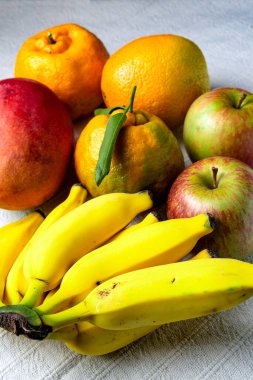 Masanın üzerinde beyaz masa örtüsü olan tropik meyve karışımı..