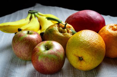 Masanın üzerinde beyaz masa örtüsü olan tropik meyve karışımı..