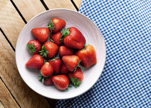有木制背景的盘中美味的多汁草莓 — 图库照片