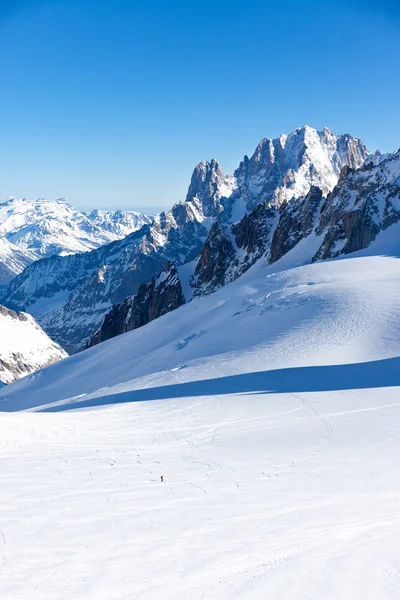 Samotny narciarz idzie w dół wzdłuż Valle Blanche, offpiste uruchomić który łączy Włochy do Francji. W tle Aiguille Verte i szczyty Drus. Chamonix, Francja, Europa. — Zdjęcie stockowe