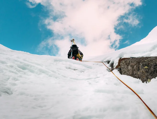 Arrampicata su ghiaccio: alpinista su un percorso misto di neve e roccia duri — Foto Stock