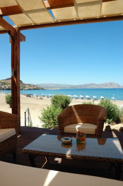 Sandalye ve bir sahil bar tablosu