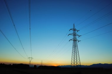 Powerlines extend to the horizon at dusk clipart