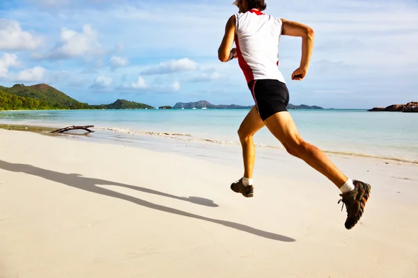 Uomo che corre su una spiaggia tropicale — Foto Stock