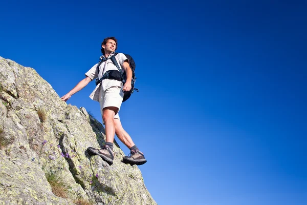 Jeune homme debout sur un rocher — Photo