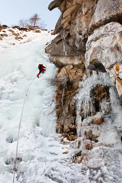 Ice climber on a steep ice fall — Stock Photo, Image