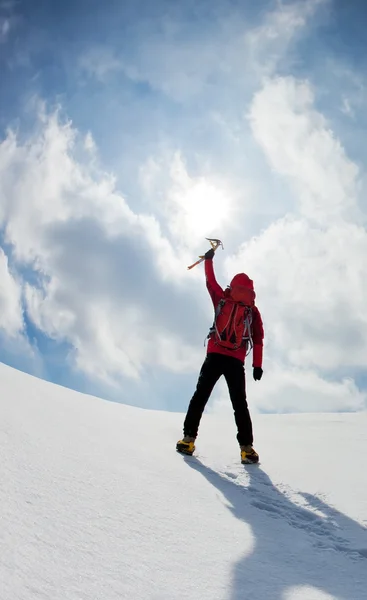 Alpinista che cammina in salita lungo un pendio innevato — Foto Stock