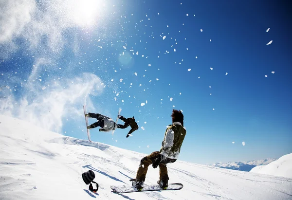 Snowboarders launching off a jump — Stock Photo, Image