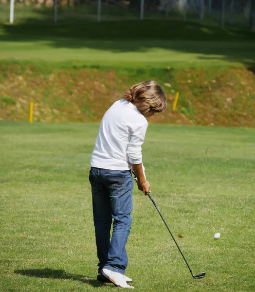 Joven golfista realiza un tiro de golf — Foto de Stock