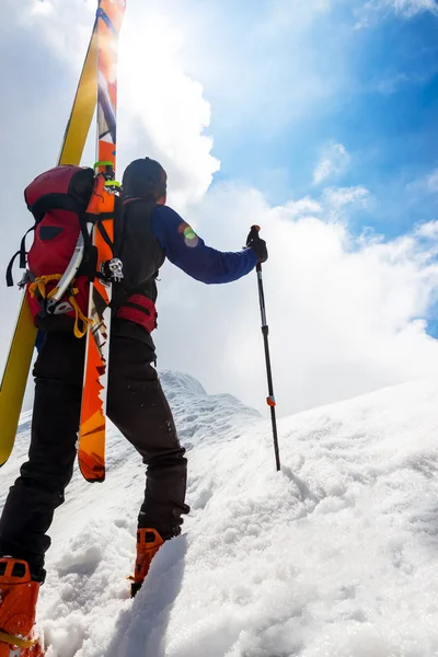 Ski montanhista andando ao longo de uma crista de neve íngreme com o s — Fotografia de Stock