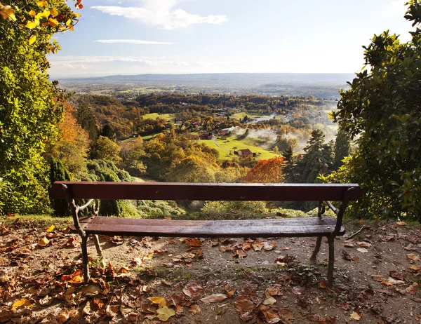 Bench in a park with views of the countryside. Stock Photo