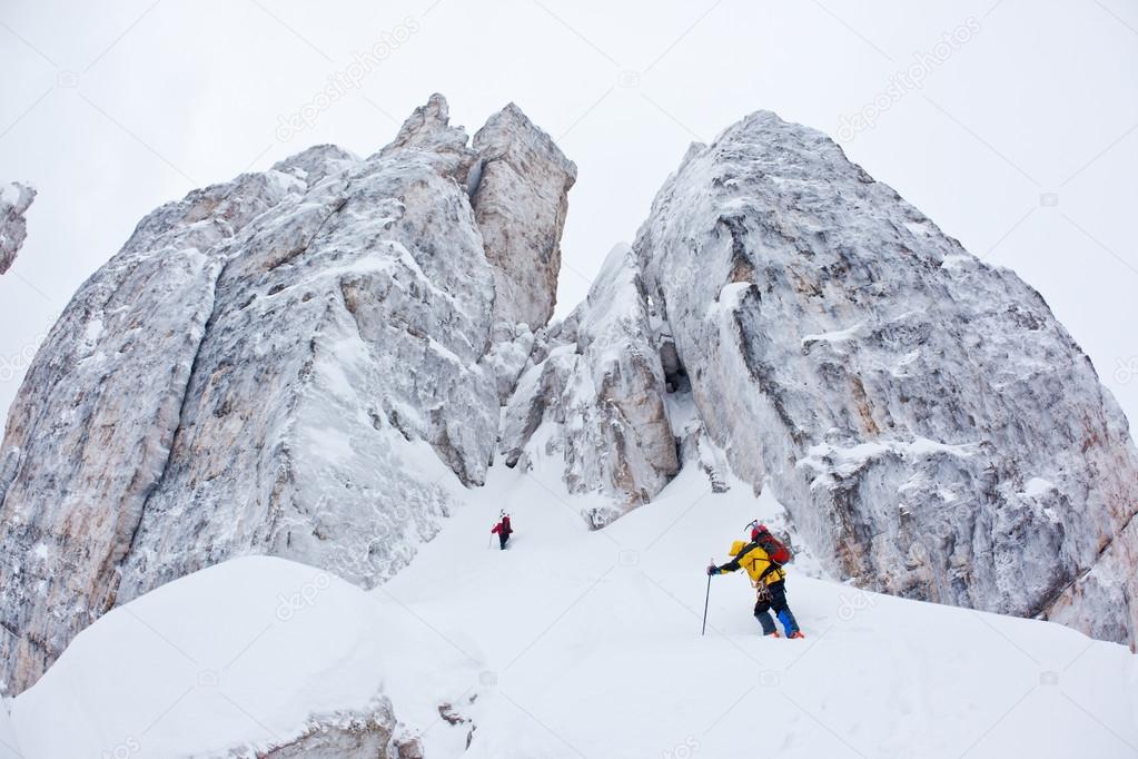 Two climbers approach to a winter steep face