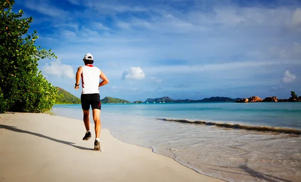 Uomo che corre su una spiaggia tropicale — Foto Stock