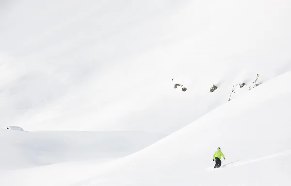 Snowboarder descend dans la neige poudreuse fraîche dans une montagne d'hiver — Photo