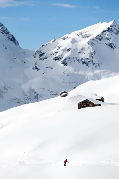 Snowboardzista pójdzie z górki na śnieżny krajobraz górski. — Zdjęcie stockowe