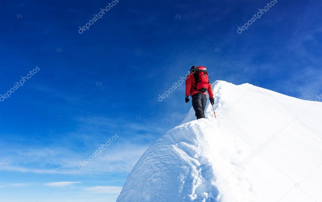 Mountaineer reach the summit of a snowy peak. Concepts: determin